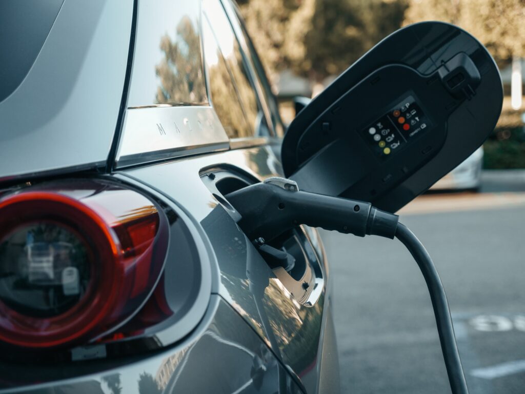 Image of an electric car charging port during recharge with "EMPOWER: EV FRIENDLY WORKPLACES" overlapped beside the EMPOWER logo.